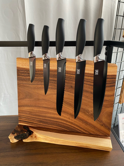 Live edge wood magnetic knife holder on a countertop base holding chef knives